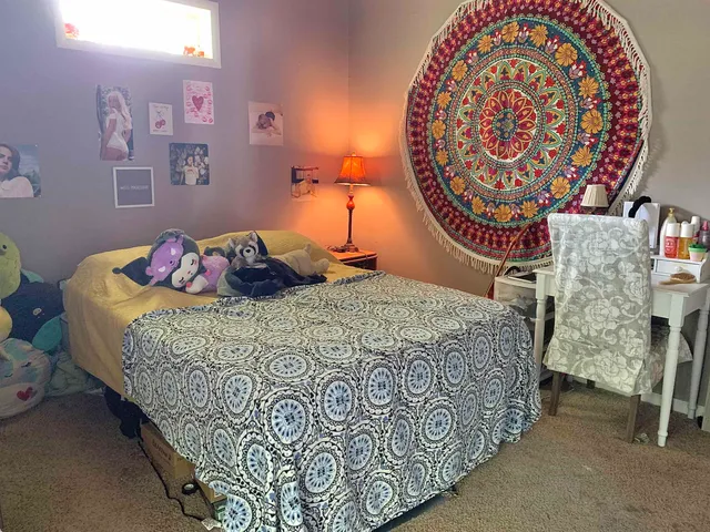 a bedroom with a bed and a lamp on dresser