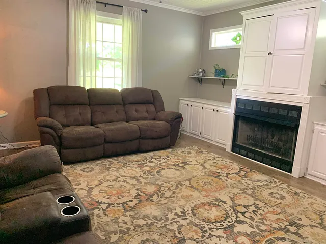 a living room with a couch a fireplace a counter top space and a window