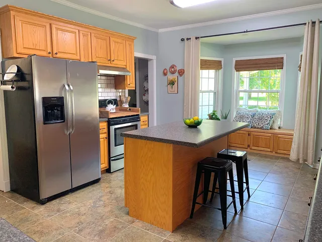 a kitchen with stainless steel appliances granite countertop a refrigerator a stove and a more cabinets