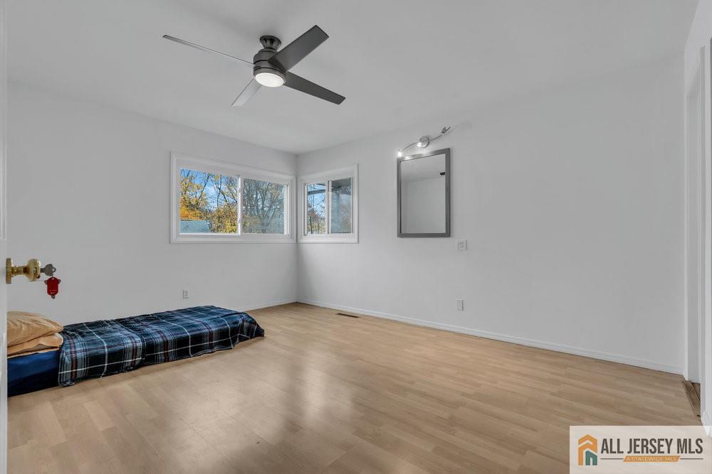 36 New Road Kendall Park, NJ 08824 - Photo 17 of 30 a view of an empty room with a window and wooden floor