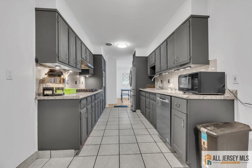 36 New Road Kendall Park, NJ 08824 - Photo 5 of 30 a kitchen with stainless steel appliances granite countertop a sink stove and cabinets