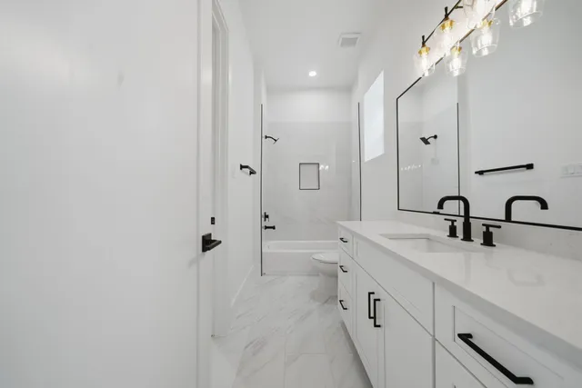 a spacious bathroom with a double vanity sink double mirror and bathtub