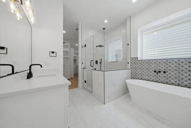 a spacious bathroom with a tub sink and mirror