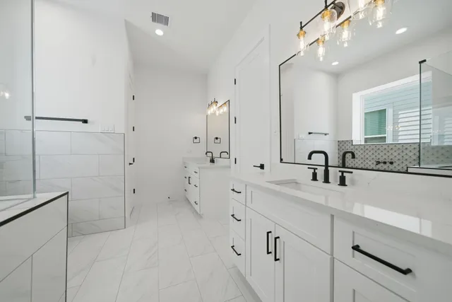 a large white bathroom with a double vanity sink a mirror and shower