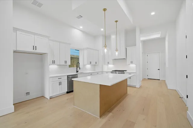 a large kitchen with cabinets and stainless steel appliances