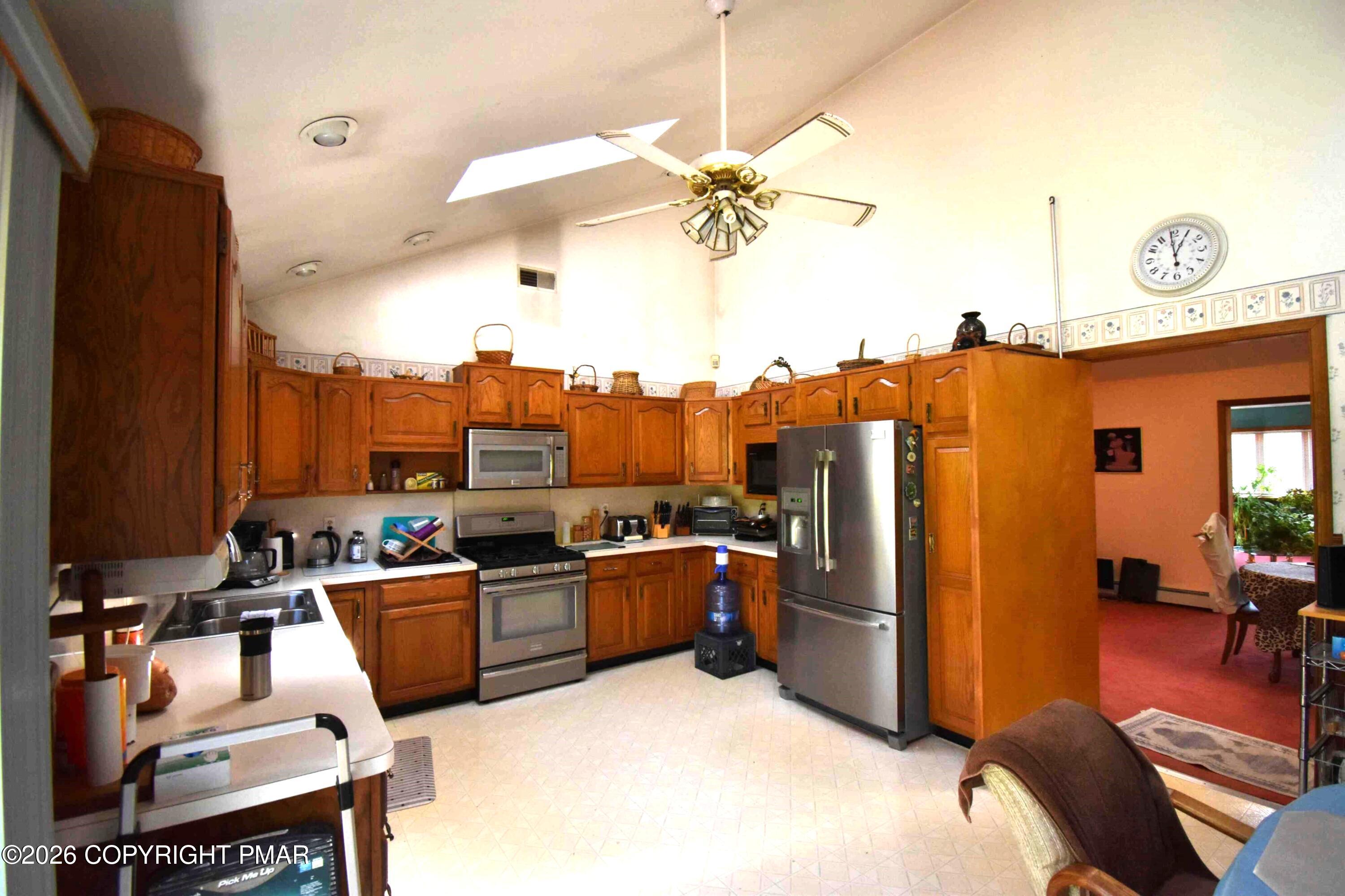 160 Quiet Valley Road Mount Bethel, PA 18343 - Photo 18 of 44 a kitchen with a refrigerator a stove and a dining table with wooden floor