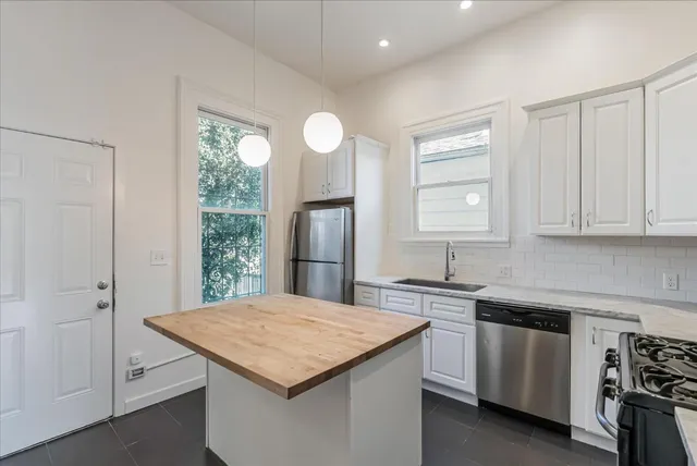 a kitchen with a stove a sink a refrigerator and cabinets