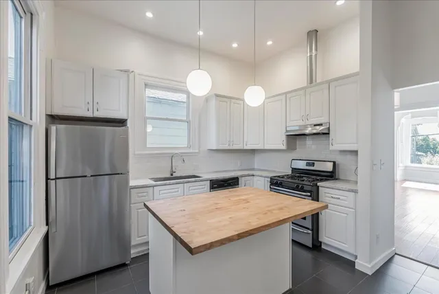 a kitchen with a refrigerator a sink and a stove top oven