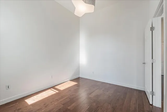a view of a small space with wooden floor and a window