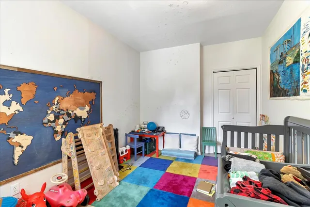 a living room with furniture and a baby crib