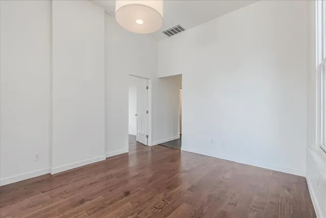 a view of an empty room with wooden floor