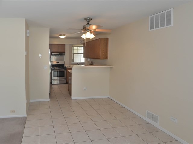 994 Ridgefield Lane, Unit 994 Wheeling, IL 60090 - Photo 7 of 19 a view of a kitchen with a sink and a refrigerator