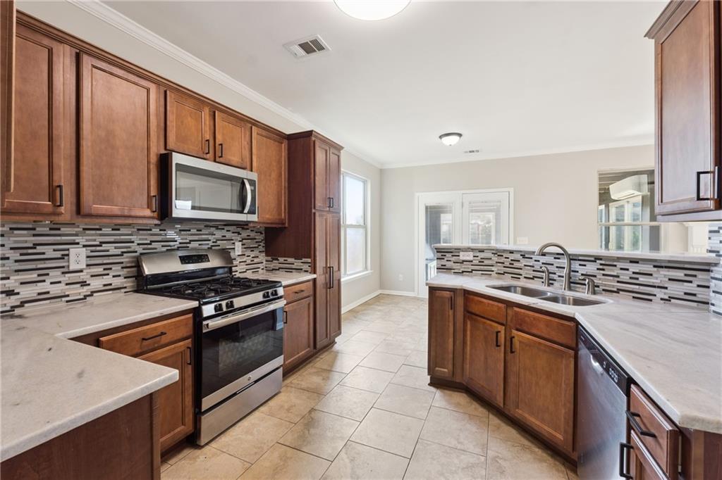 a kitchen with stainless steel appliances a stove sink and microwave