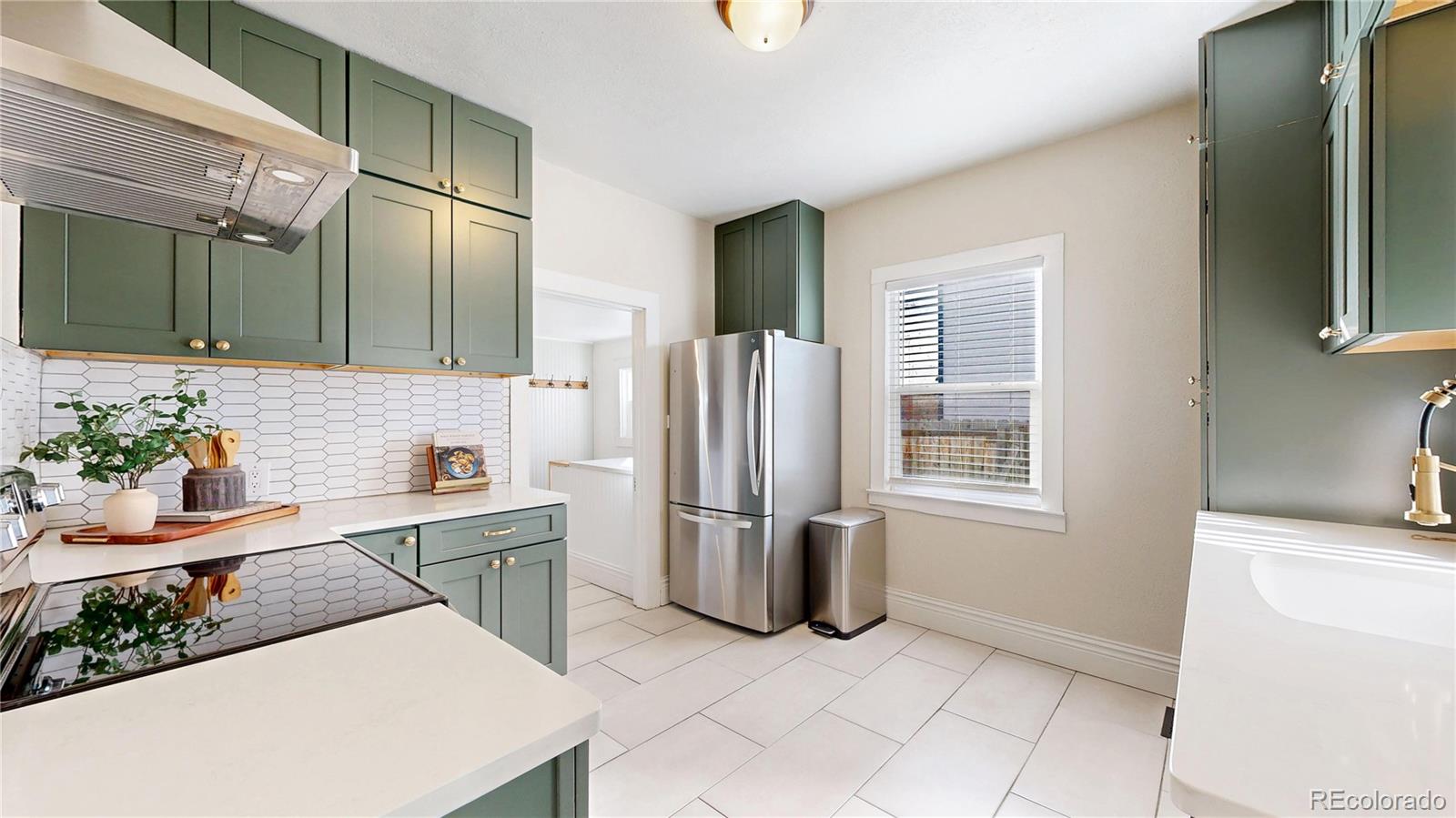 4890 Irving Street Denver, CO 80221 - Photo 12 of 35 a kitchen with stainless steel appliances granite countertop a refrigerator and a sink