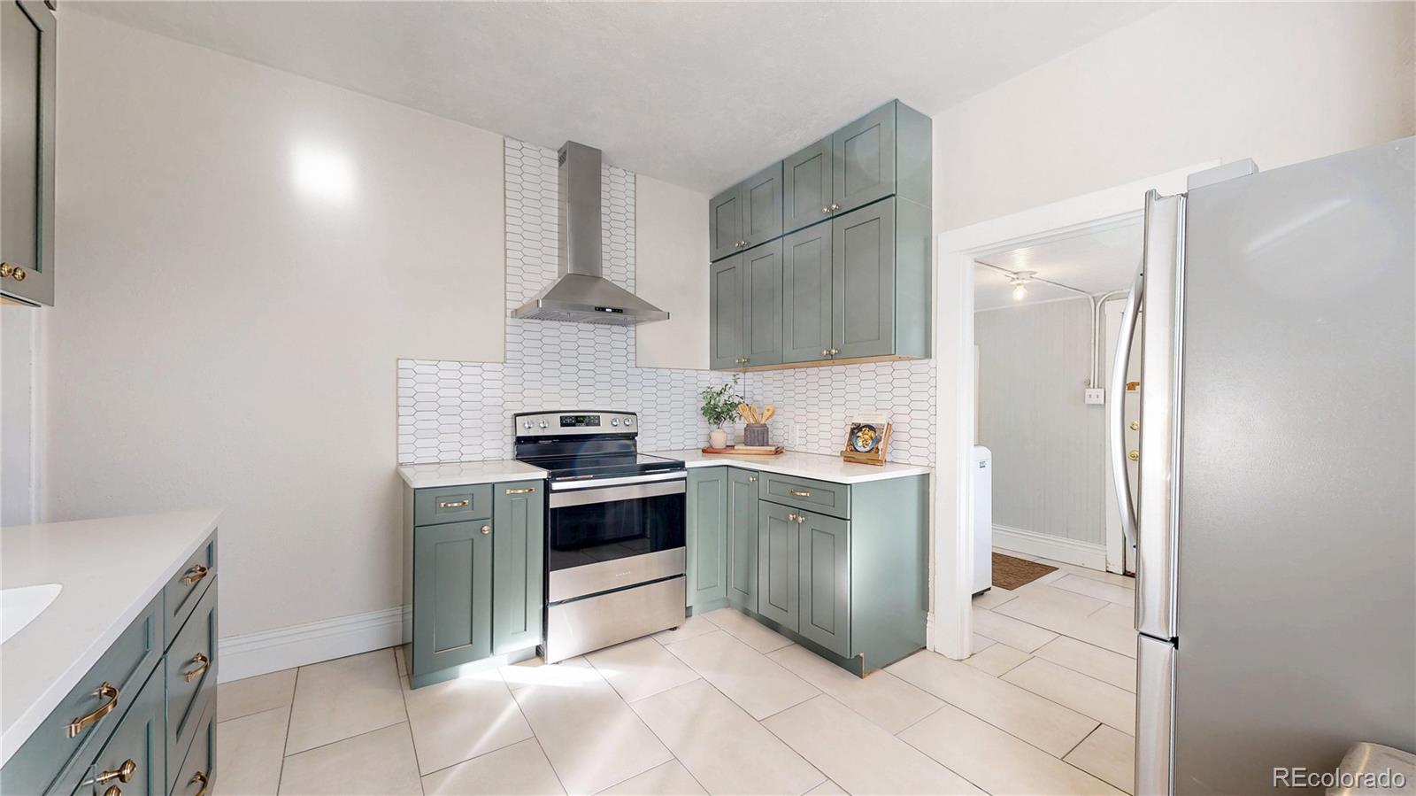 4890 Irving Street Denver, CO 80221 - Photo 13 of 35 a kitchen with stainless steel appliances granite countertop a refrigerator and a sink