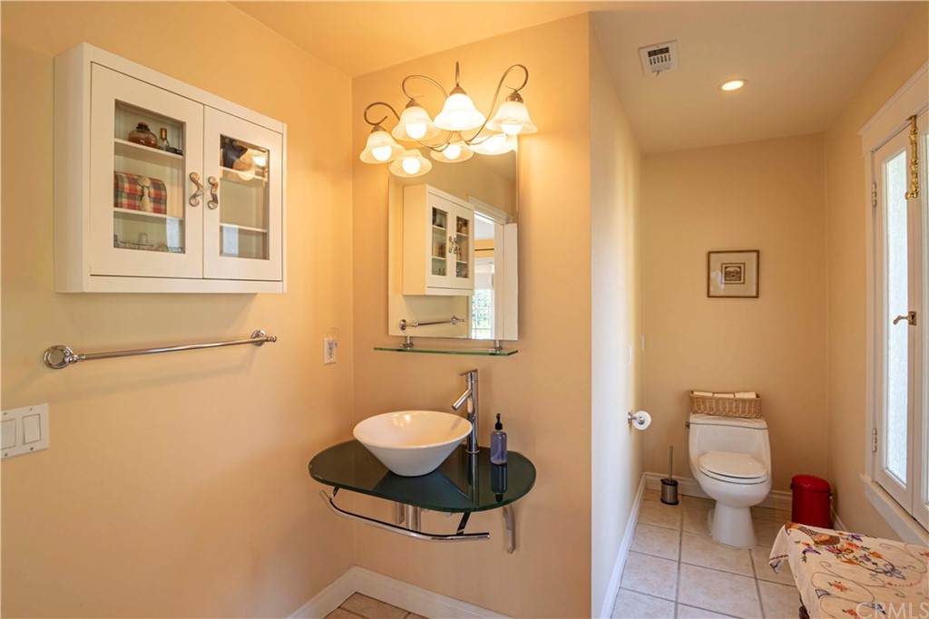 2915 Lakemont Drive Fallbrook, CA 92028 - Photo 16 of 56 a bathroom with a sink a toilet and a mirror