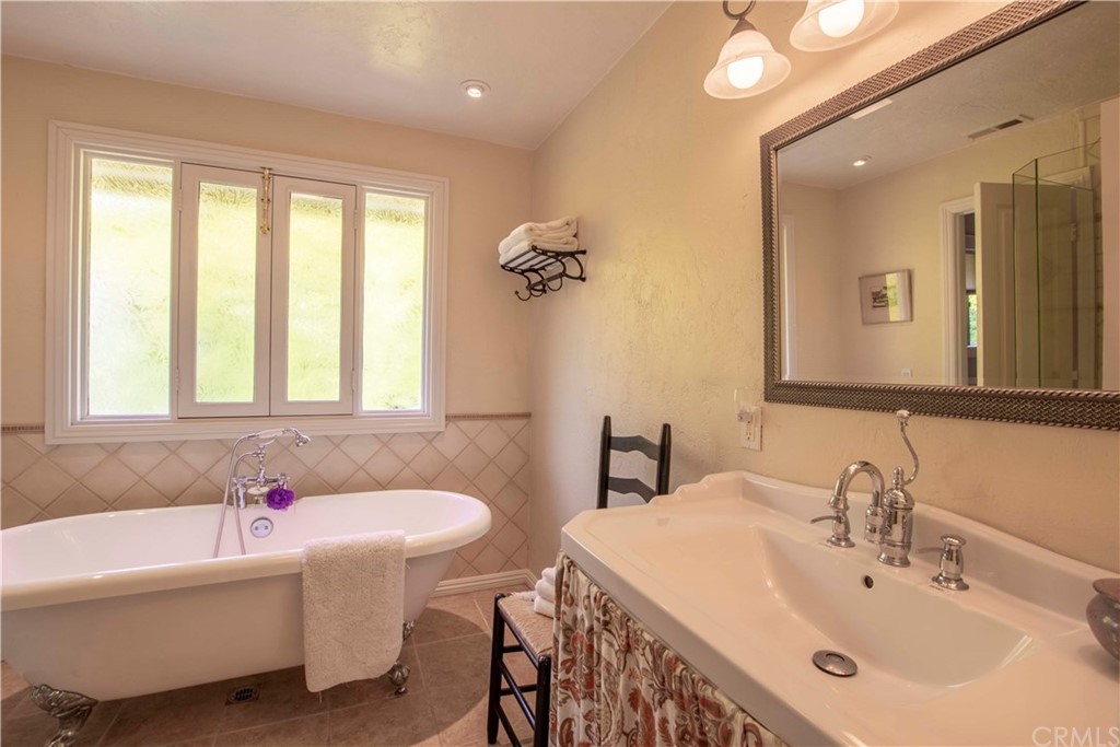 2915 Lakemont Drive Fallbrook, CA 92028 - Photo 22 of 56 a bathroom with a bathtub a sink and a window