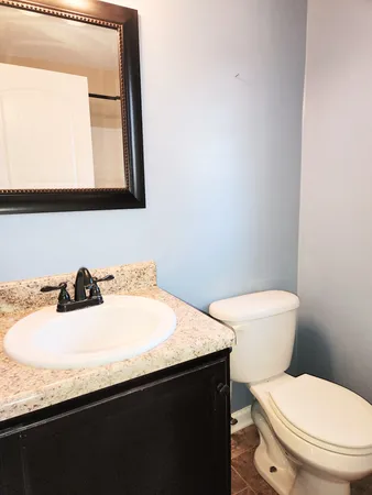 a bathroom with a sink a toilet and mirror