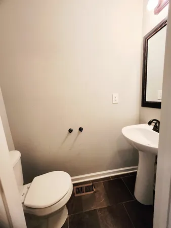 a bathroom with a toilet a sink and mirror