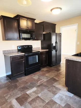 a kitchen with stainless steel appliances granite countertop a stove a refrigerator and a sink