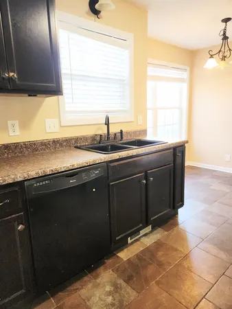 a kitchen with a sink a window and cabinets