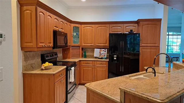 a kitchen with stainless steel appliances granite countertop a refrigerator and a stove