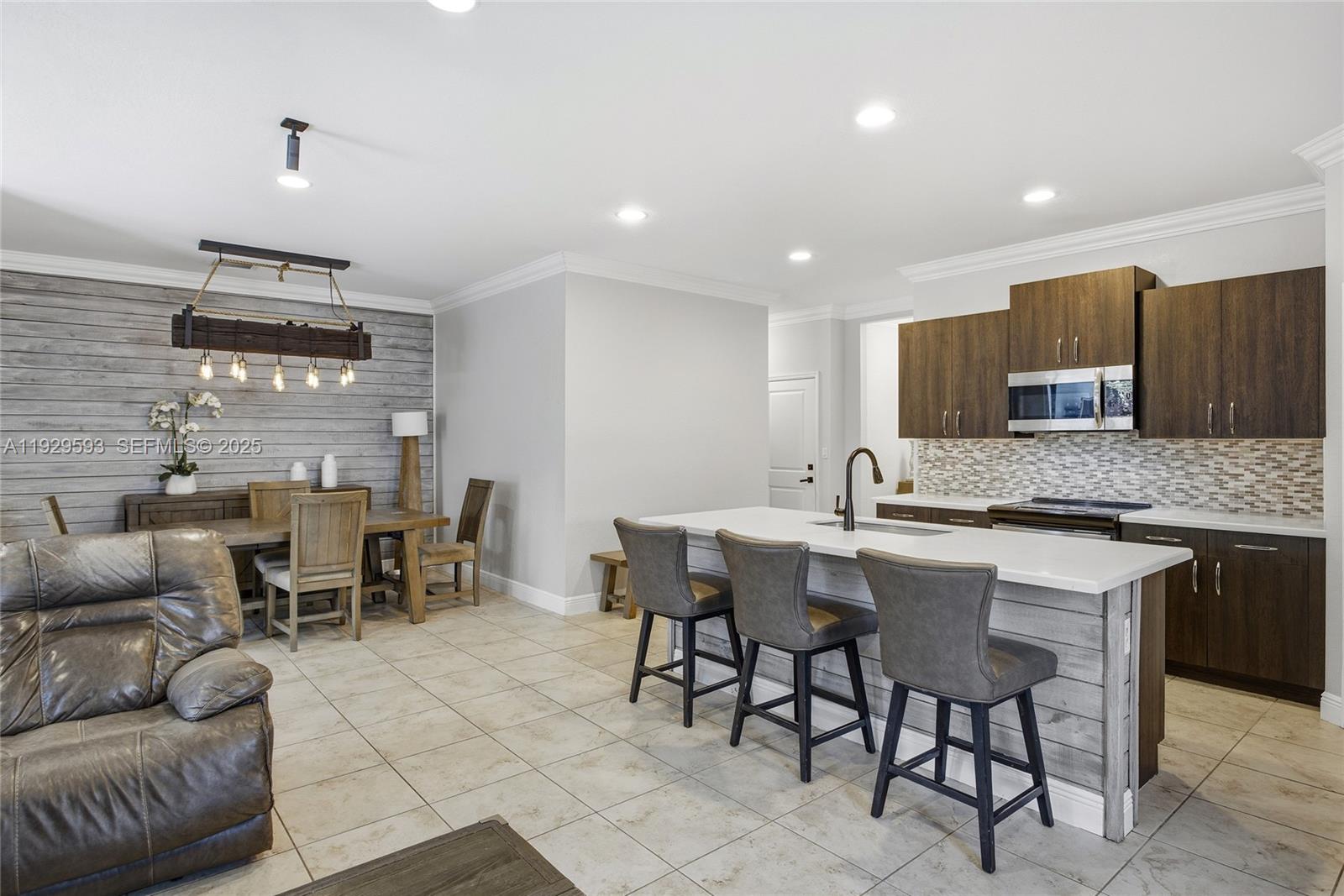 27641 Southwest 134th Court Homestead, FL 33033 - Photo 19 of 40 a kitchen with stainless steel appliances granite countertop a sink a stove a dining table and chairs