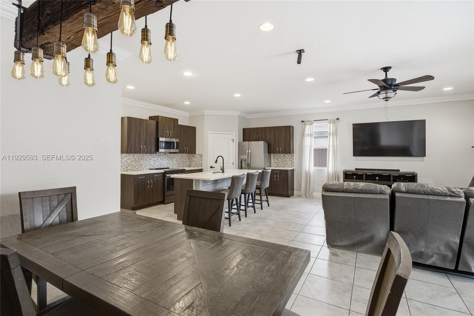 27641 Southwest 134th Court Homestead, FL 33033 - Photo 20 of 40 a living room with stainless steel appliances couches a flat screen tv and kitchen view