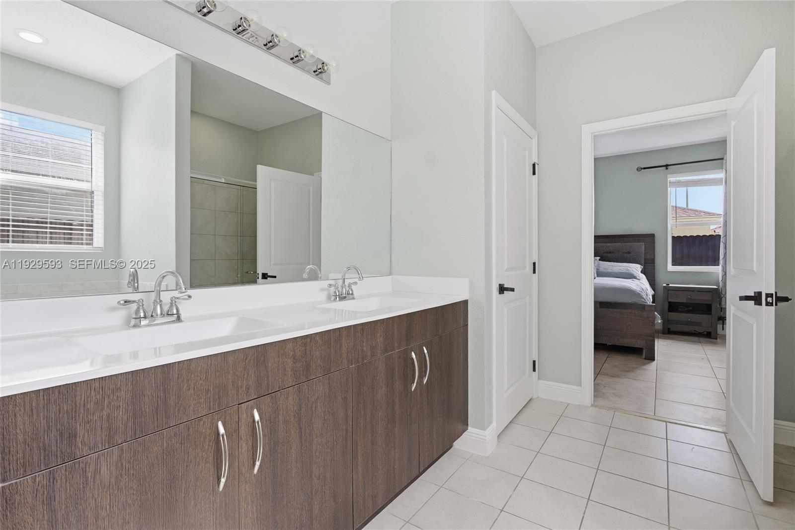 27641 Southwest 134th Court Homestead, FL 33033 - Photo 24 of 40 a en suite bathroom with a double sink and mirror