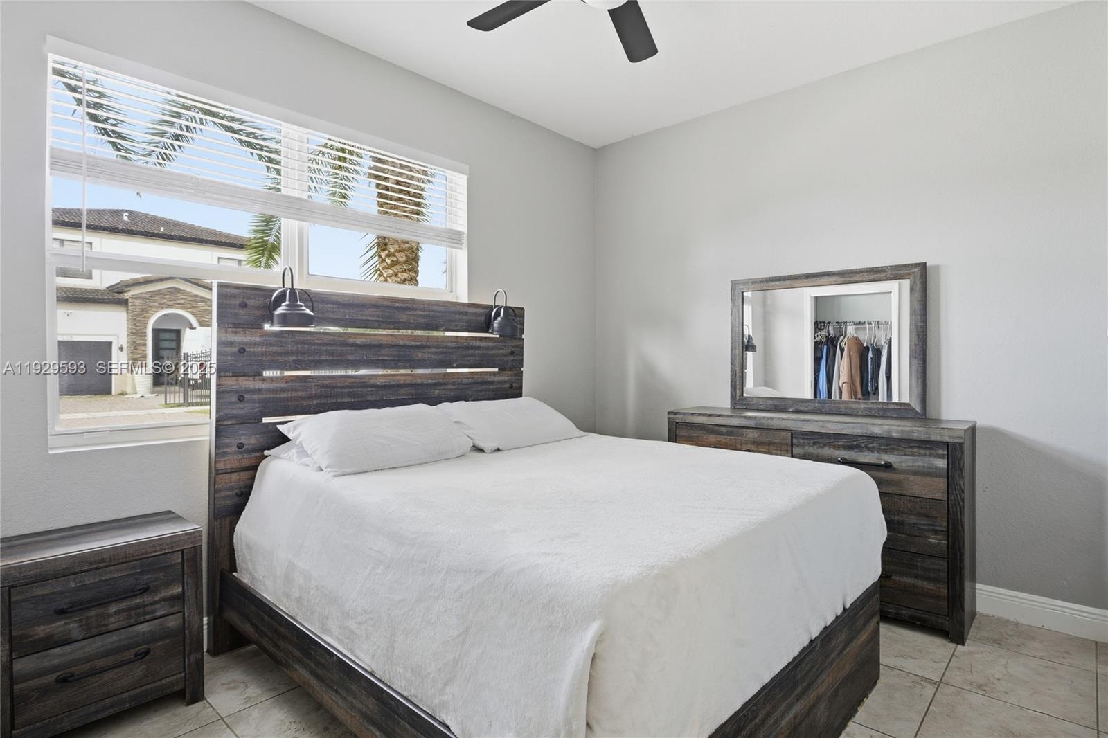 27641 Southwest 134th Court Homestead, FL 33033 - Photo 28 of 40 a bedroom with a bed and a chandelier