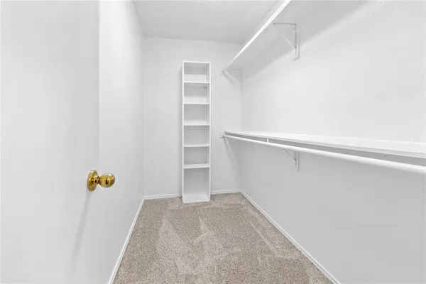 a view of walk in closet with empty racks