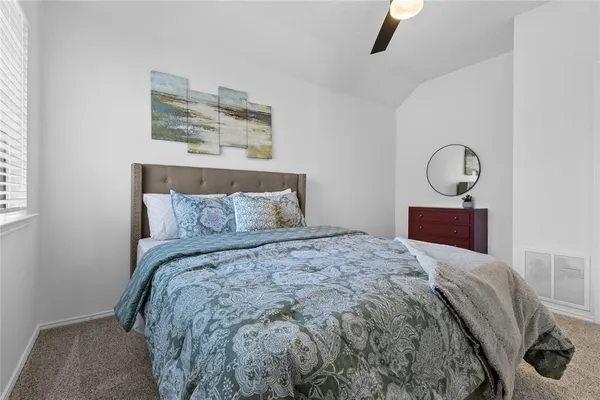 a bedroom with a bed and painting on the wall