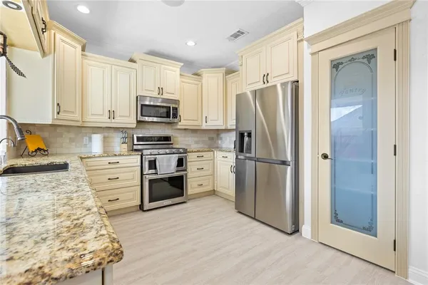 a kitchen with white cabinets and stainless steel appliances