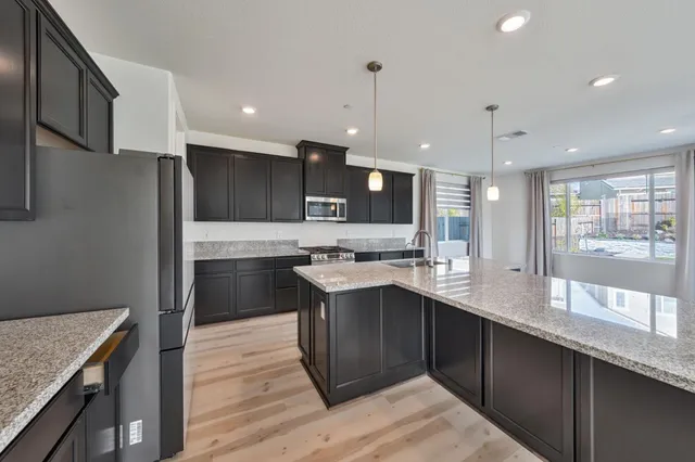 a kitchen with a sink stainless steel appliances and cabinets