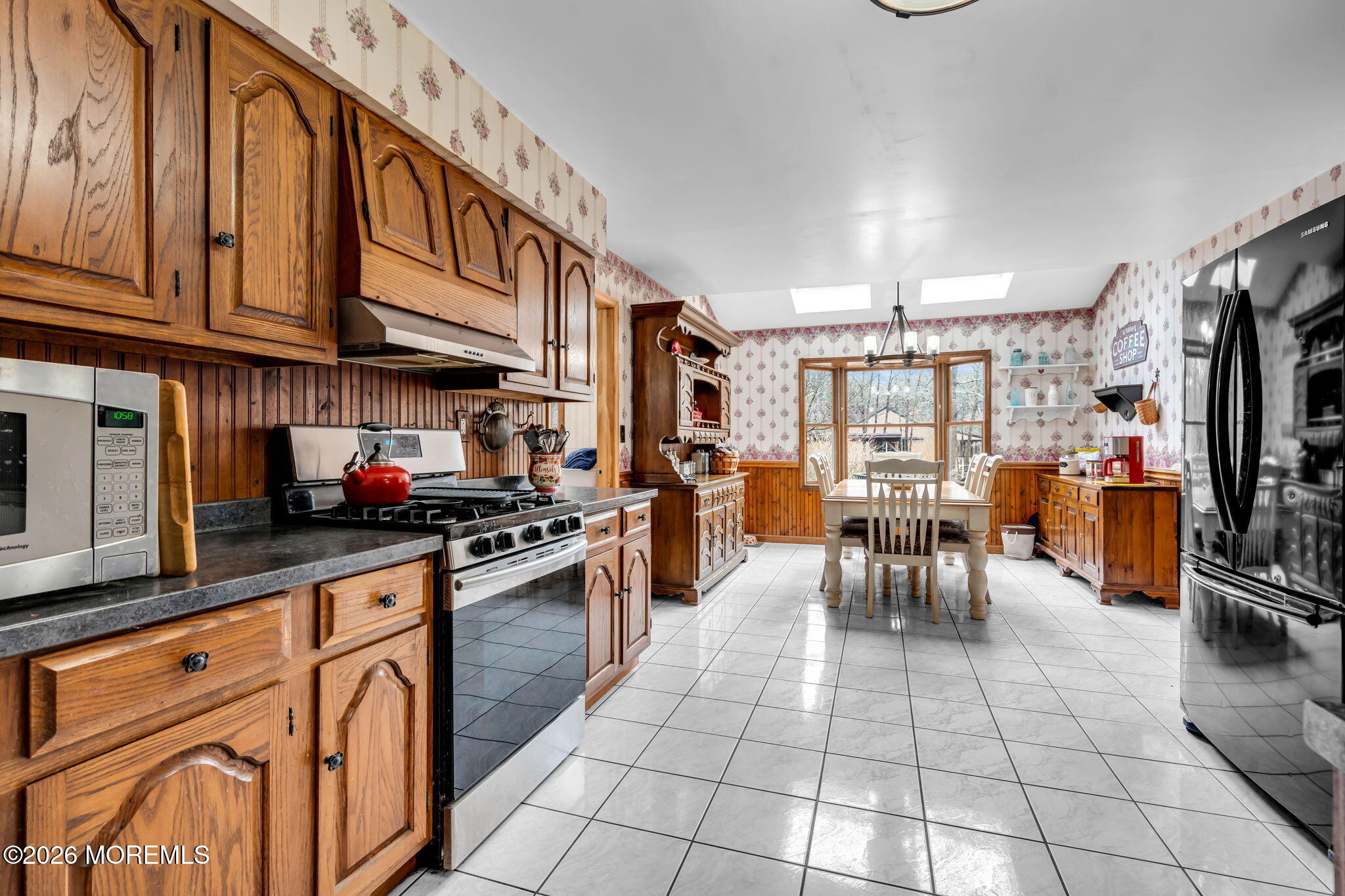106 Vienna Road Howell, NJ 07731 - Photo 8 of 59 a kitchen with stainless steel appliances granite countertop a stove top oven a sink a dining table and chairs with wooden floor