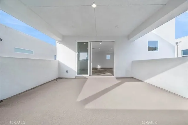 a view of an empty room with cabinet and a window