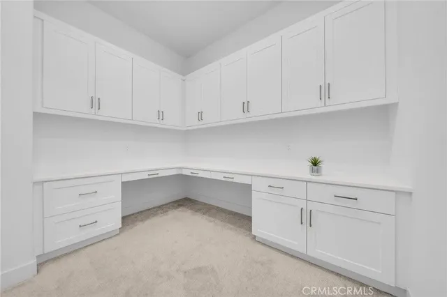 a kitchen with white cabinets and a refrigerator