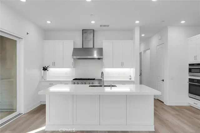 a kitchen with kitchen island a sink a stove and a refrigerator