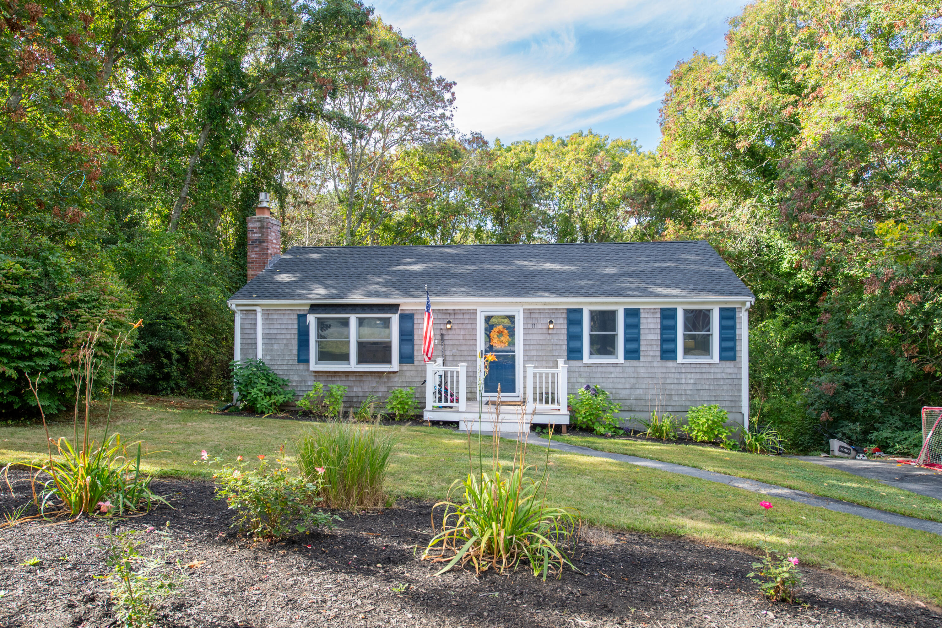 11 Warwick Way Mashpee, MA 02649 - Photo 2 of 67 a view of a yard in front of a house with large windows