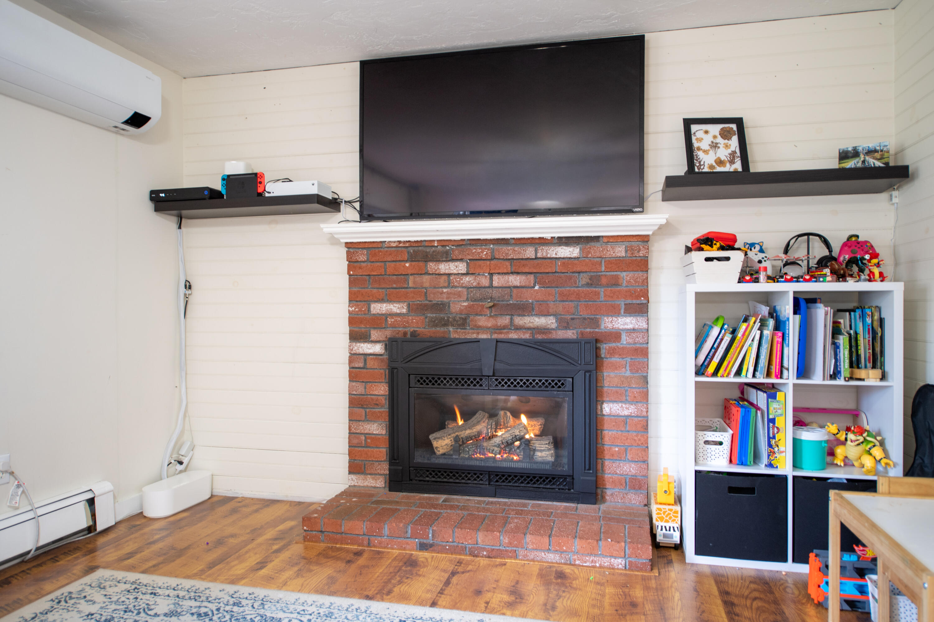 11 Warwick Way Mashpee, MA 02649 - Photo 6 of 67 a living room with bookshelf and a fireplace