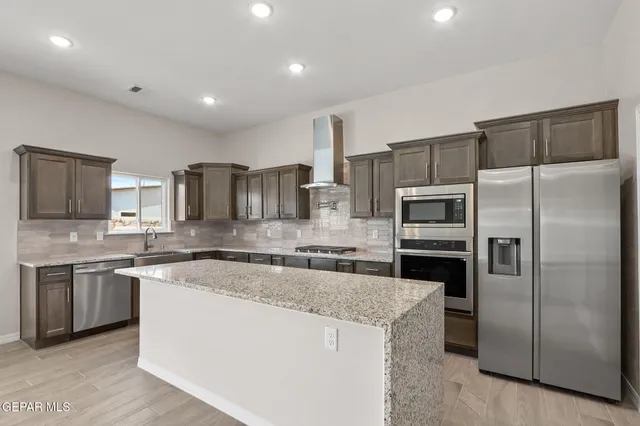 a large kitchen with stainless steel appliances and a sink