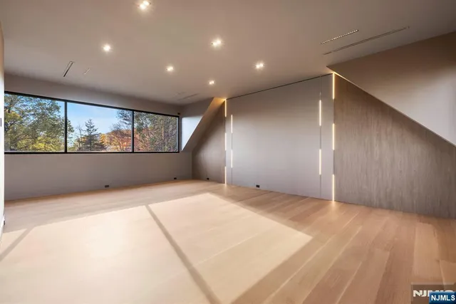 a view of empty room with wooden floor and windows