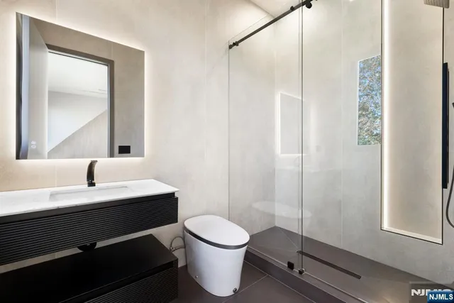 a bathroom with a toilet a sink and a mirror