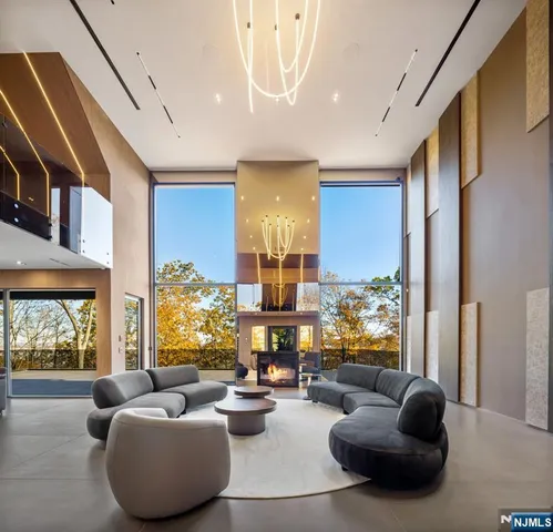 a living room with furniture fireplace and large windows