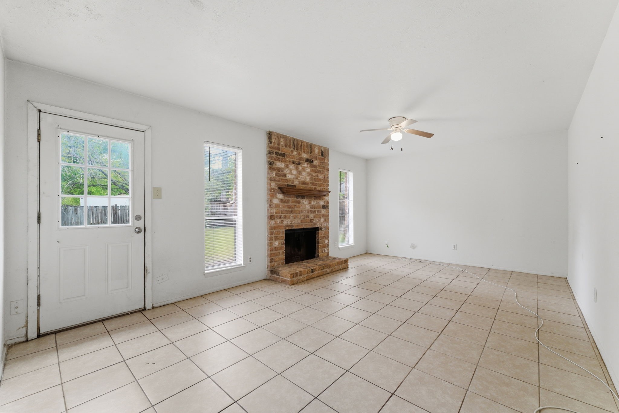 6914 Ten Curves Road Spring, TX 77379 - Photo 12 of 26 Large living room with wood burning fireplace and door to backyard.