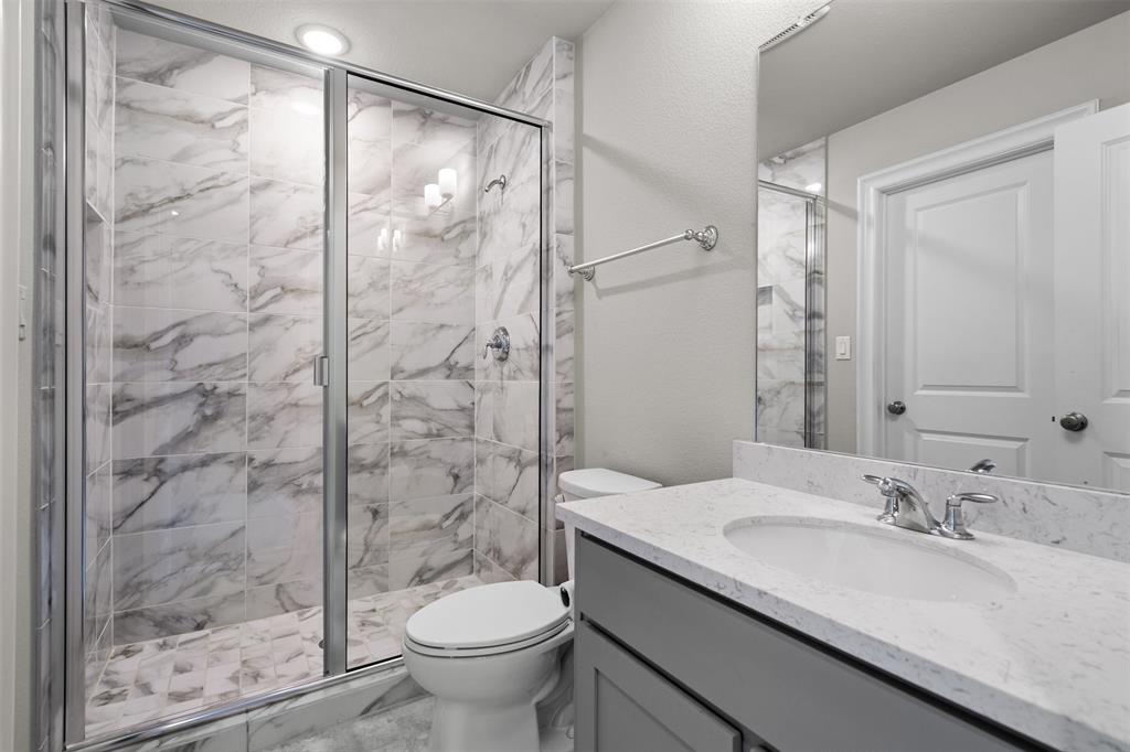 4505 Fall Mdw Drive Prosper, TX 75078 - Photo 19 of 34 a bathroom with a granite countertop sink toilet and shower