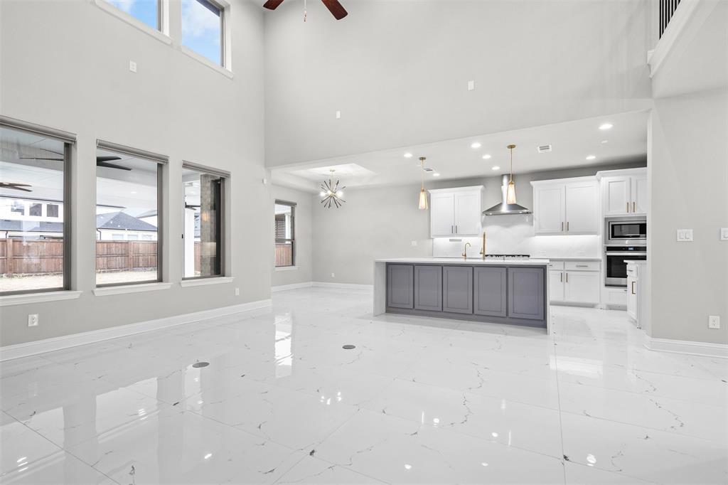 4505 Fall Mdw Drive Prosper, TX 75078 - Photo 9 of 34 a large kitchen with stainless steel appliances a large counter top a stove and a refrigerator