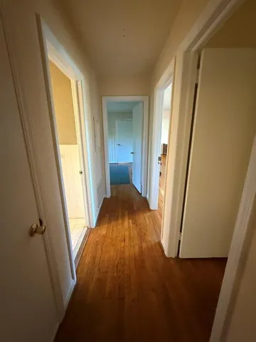 a view of a room with wooden floor and a window
