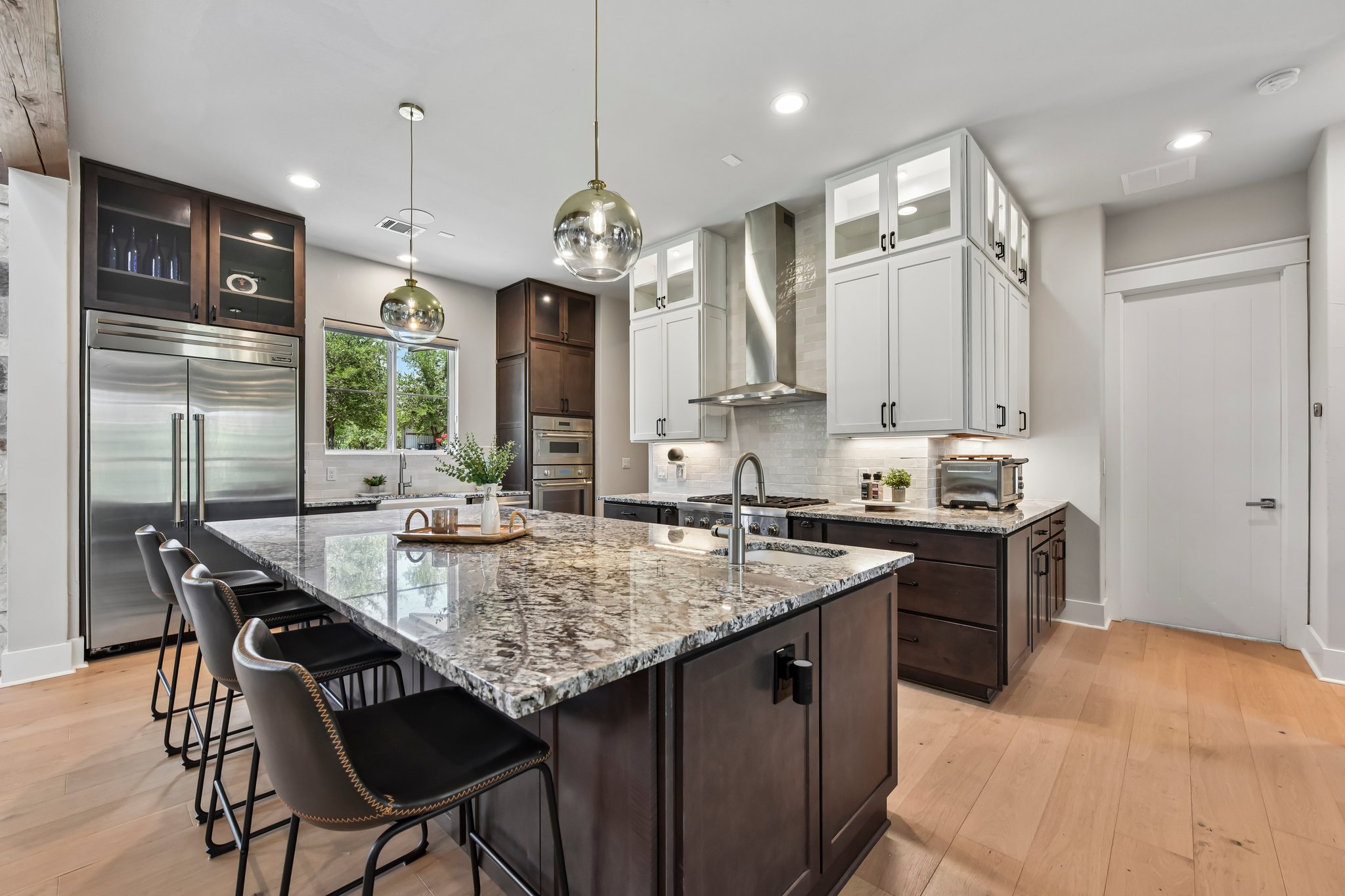 2203 Improver Road Spicewood, TX 78669 - Photo 4 of 38 A well-appointed culinary space featuring sleek stainless steel appliances and a central island with an integrated sink, ideal for gatherings.