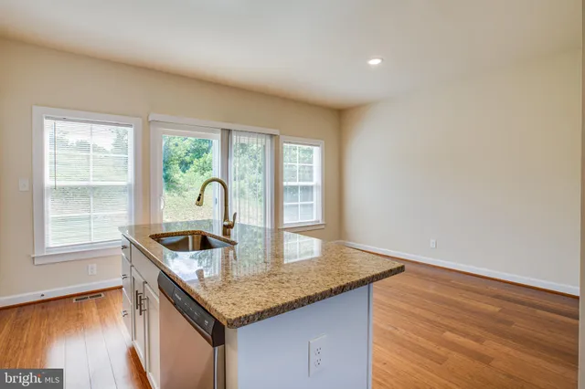 a kitchen with granite countertop a sink and stove top oven